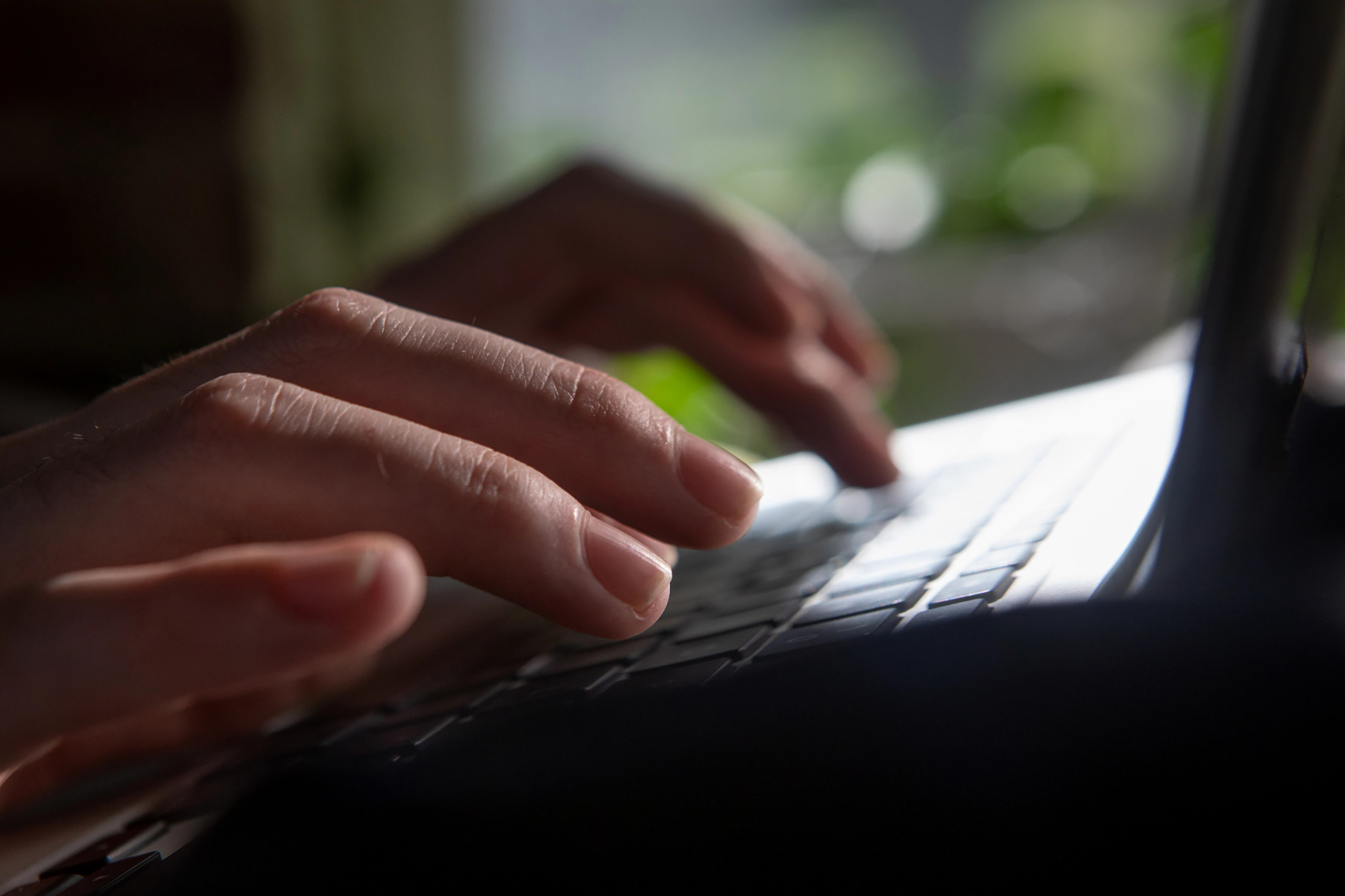 Fingers typing on a laptop keyboard